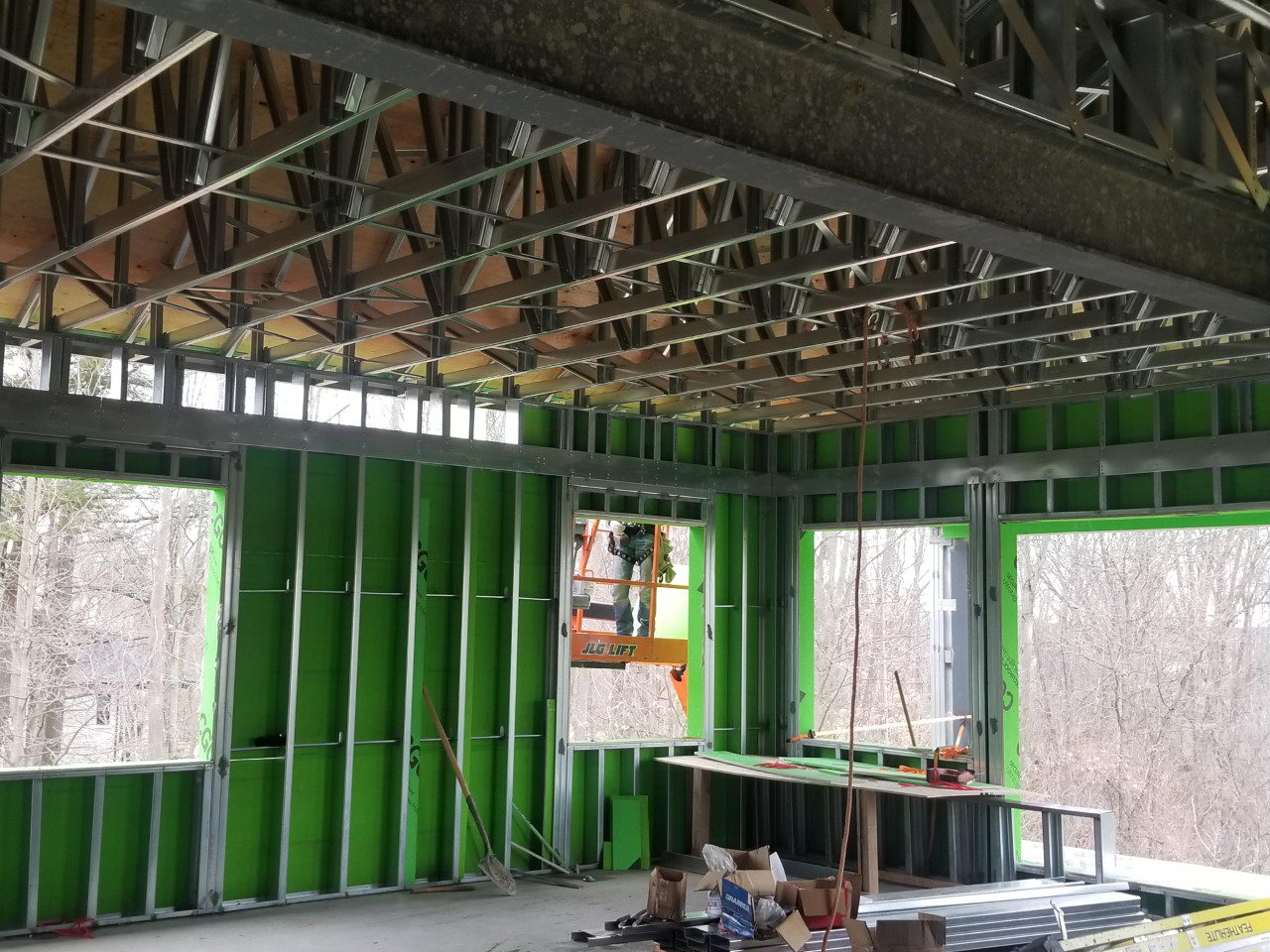 a house under construction with green walls and metal framing